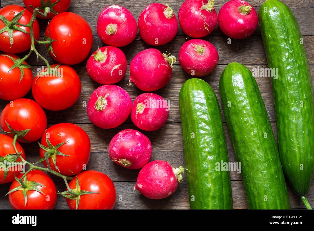 Contexte de l'agriculture. Les tomates, les radis et les concombres sur table. Les aliments crus. Gouttes d'eau sur les légumes lavés. Close up. Vue d'en haut. Banque D'Images