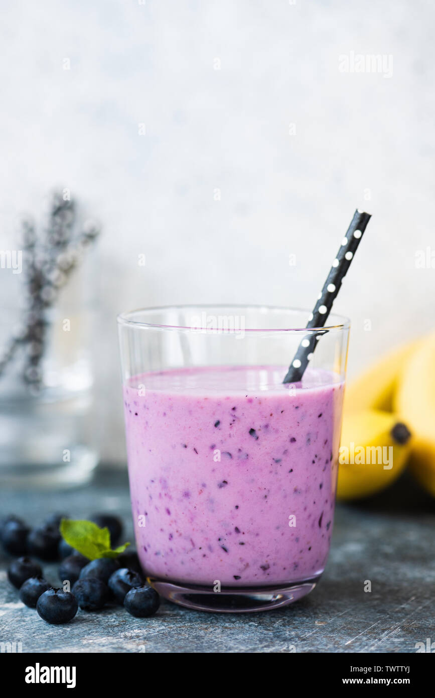 Frappé aux bleuets dans verre avec paille. La nourriture végétalienne végétarienne saine Banque D'Images