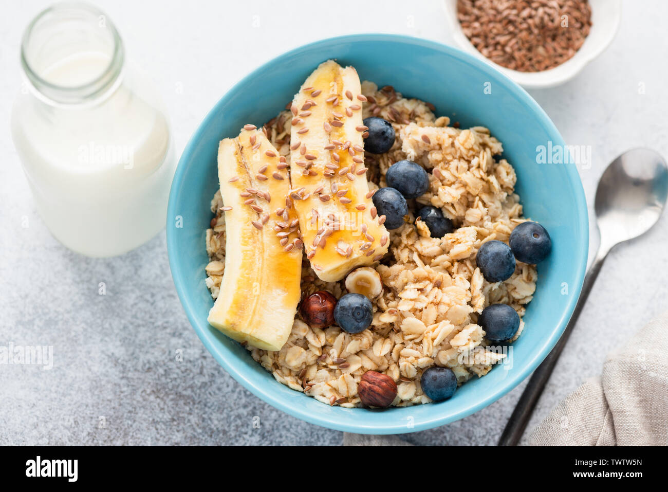 Le gruau avec des bananiers, des bleuets, de graines de lin et les noisettes. Délicieux petit déjeuner nutritif sain. Vue de dessus, gros plan Banque D'Images