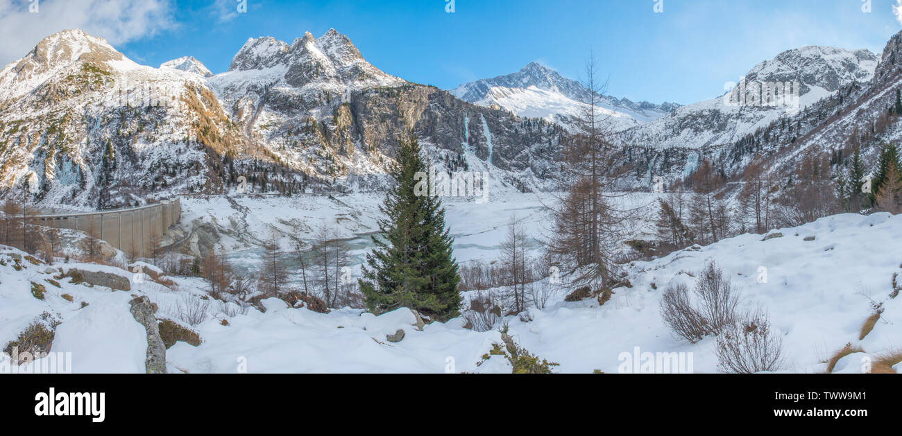 Vue panoramique sur le lac Avio dans le parc d'Adamello Brenta, Italie. Montagnes aux sommets enneigés et la vallée avec le lac artificiel et le barrage gelé. Banque D'Images