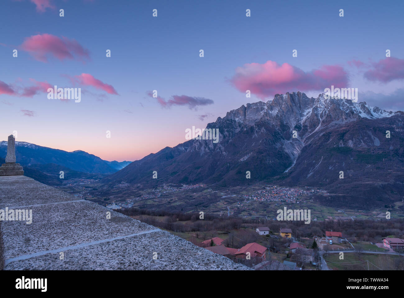 Le lever du soleil sur la ville de Cimbergo en Val Camonica, Italie. Les nuages roses sur les montagnes, les nuages colorés à l'aube dans la vallée. Banque D'Images
