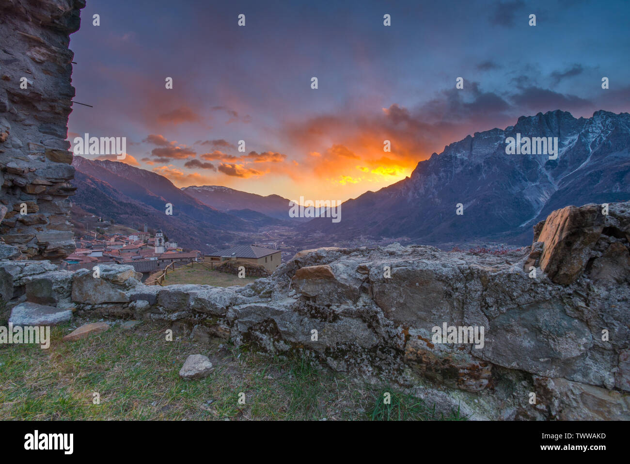 Le feu du ciel au coucher du soleil. Vivid, peint aux couleurs du ciel nuages, coucher de soleil dans la vallée de montagne. Le Val Camonica le coucher du soleil. Soleil derrière les montagnes. Banque D'Images