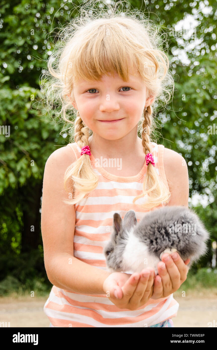 Belle fille blonde holding jeune lapin Banque D'Images