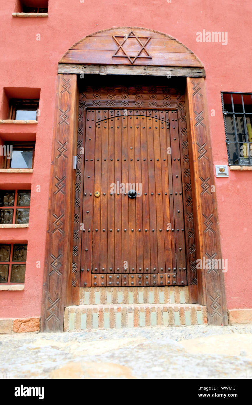 La porte en bois d'une maison espagnole à Grenade, en Espagne, avec une étoile de David sculpté au-dessus de lui ; symboles juifs en Espagne. Banque D'Images