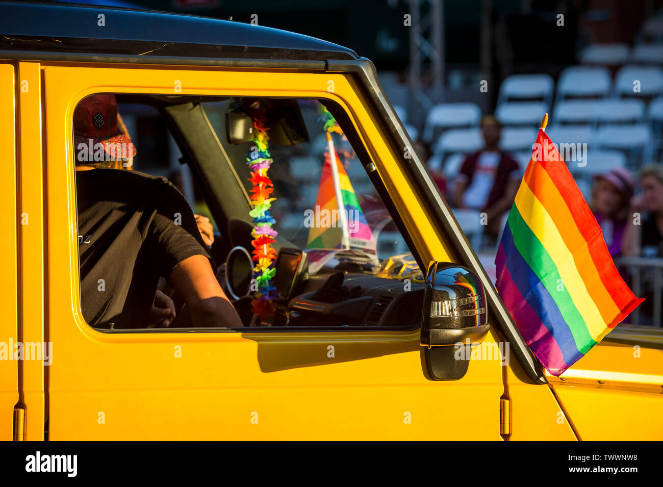 Vue de drapeaux arc-en-ciel coloré de la décoration d'une voiture roulant dans une gay pride parade dans la ville Banque D'Images