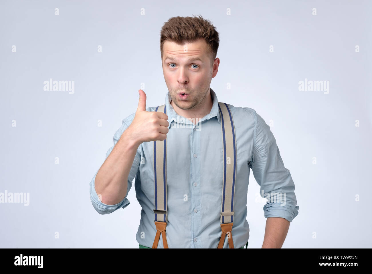 Young happy man showing Thumbs up. Studio shot Banque D'Images