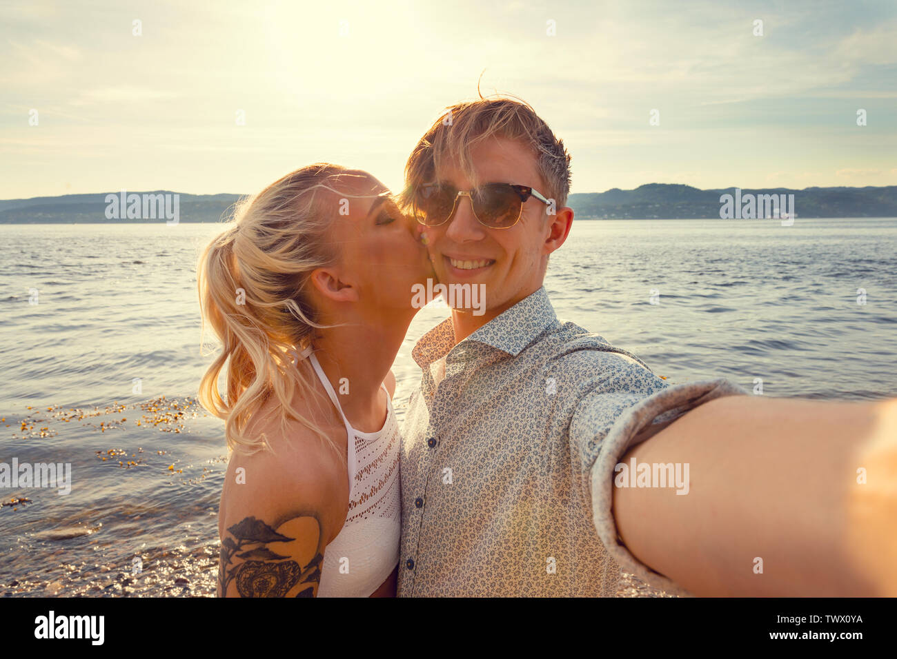Smiling Young Man Taking avec Selfies petite amie à Beach Banque D'Images