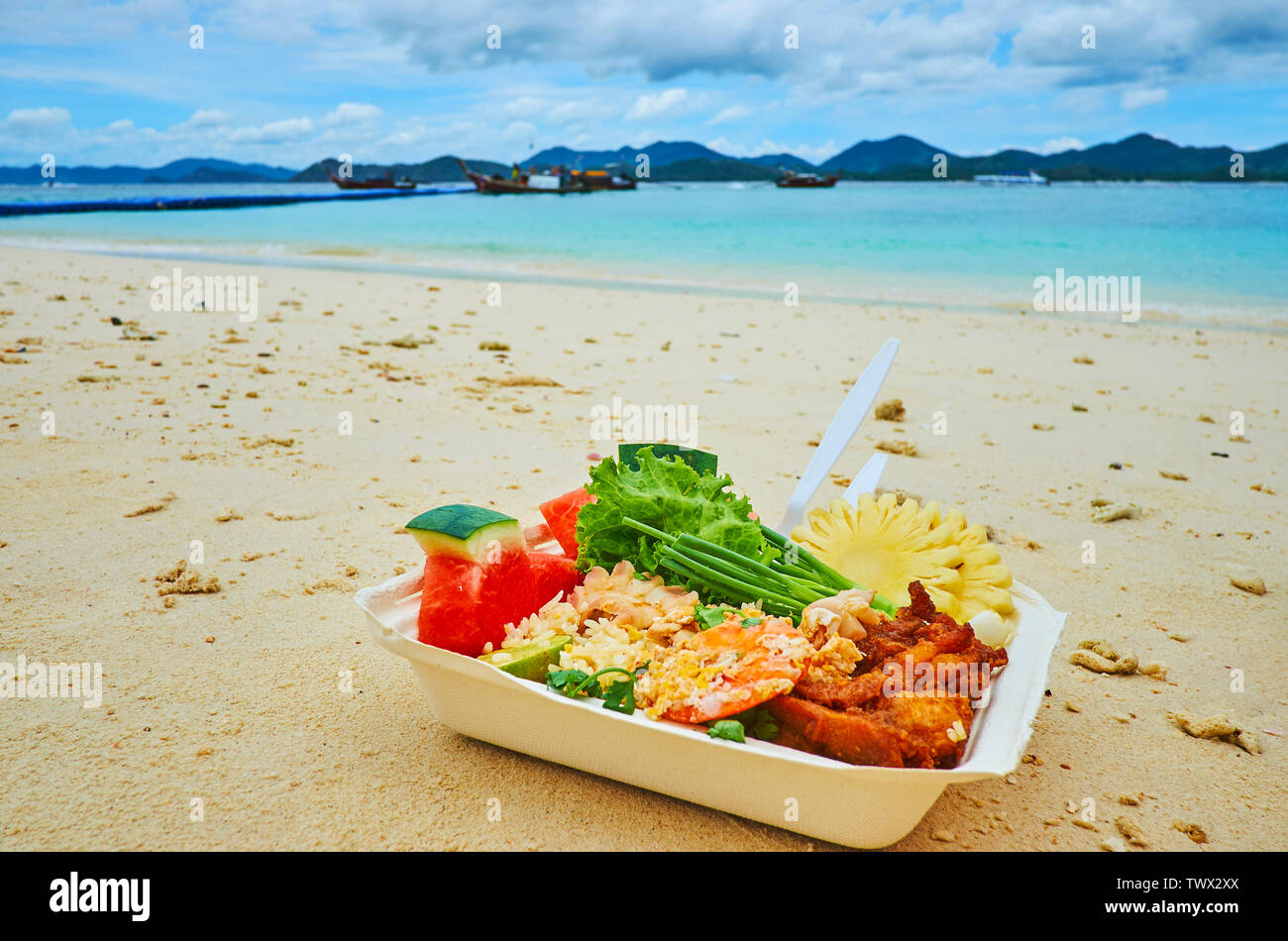 La boîte à lunch avec le plat traditionnel thaïlandais - fruits de mer grillés, le riz, les fruits et légumes frais, sur la plage de Khai Nai, Phuket, Thailand Banque D'Images