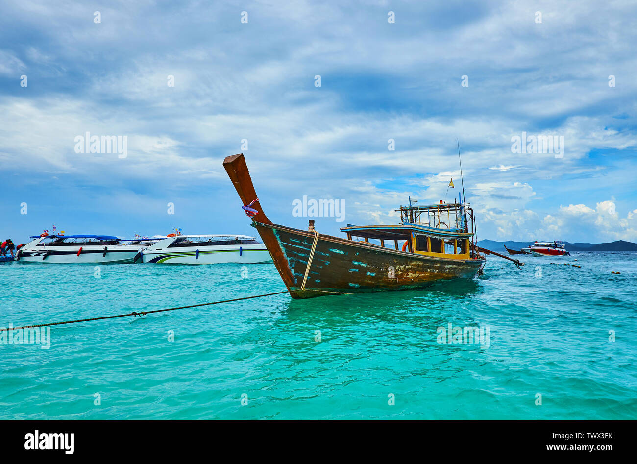 Le bateau longtail, dansant sur les eaux émeraude de la mer d'Andaman au bord du Khai Nok, Phuket, Thailand Banque D'Images