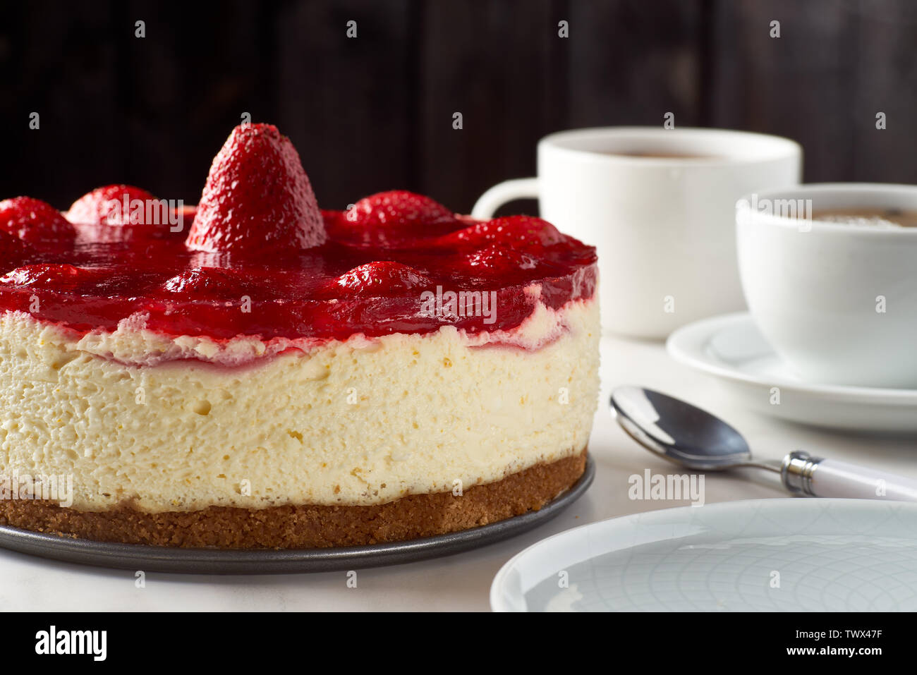 Cheesecake aux fraises et deux tasses de thé Banque D'Images