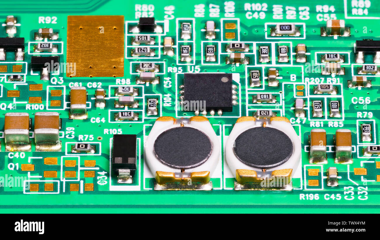 Composants électroniques. Bobines, résistances, condensateurs, transistors et puce. Arrière-plan électrotechnique. La technologie de montage en surface. Circuit vert. Banque D'Images