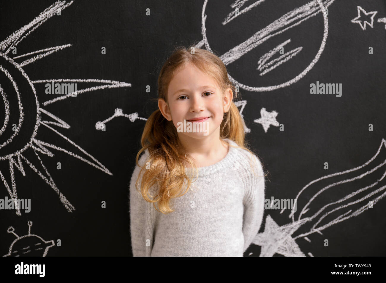Petite fille près de l'espace dessiné avec mur sombre Banque D'Images