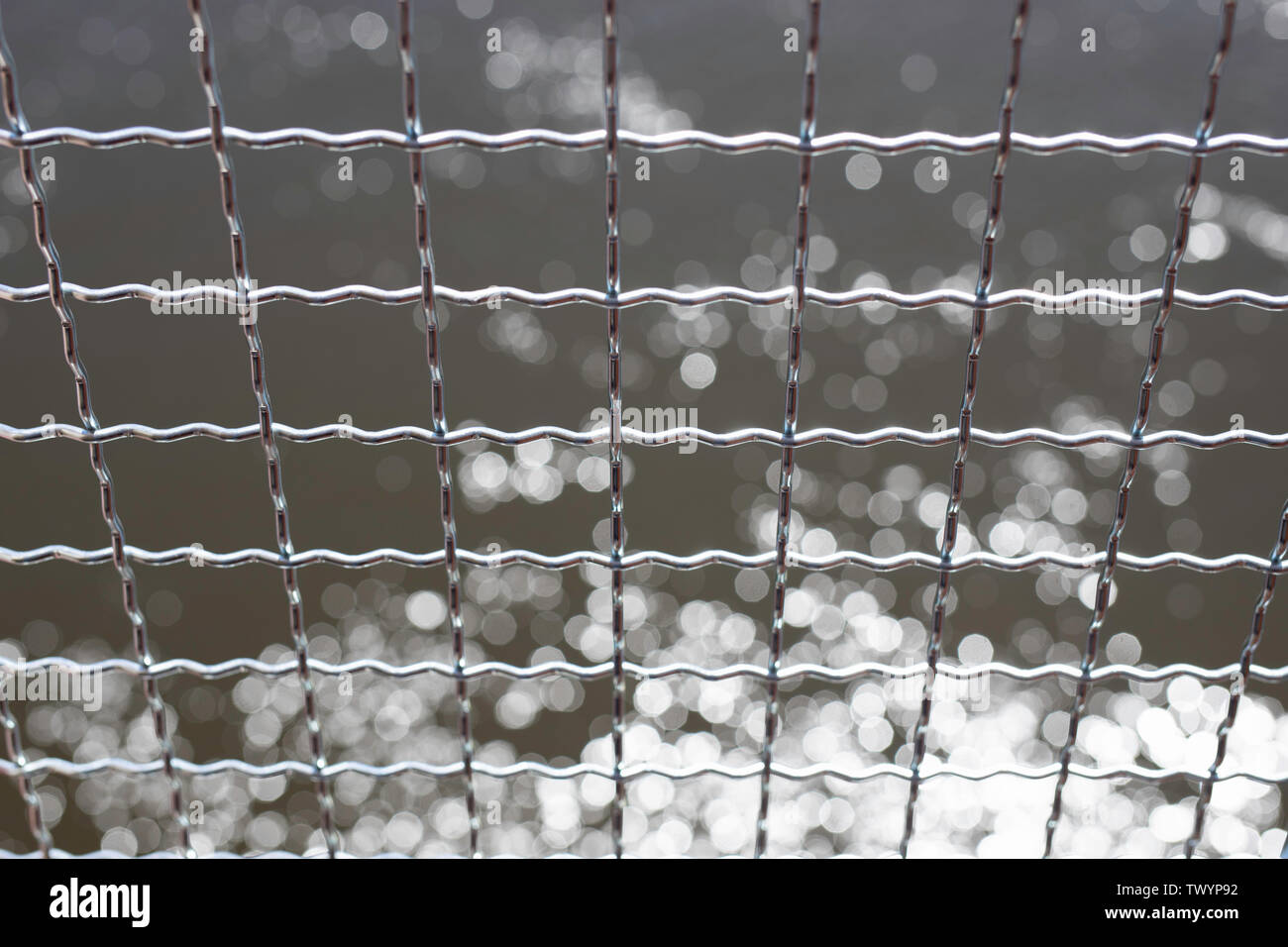 Clôture en fil ondulé ondulé, sur un navire, l'eau dans le fond. Des lignes parallèles. Banque D'Images