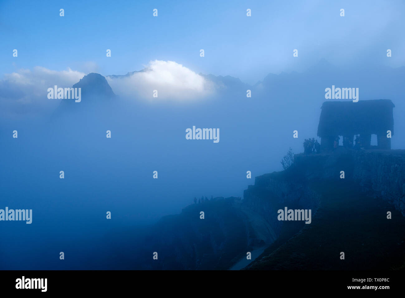 Tôt le matin, vue sur le Machu Picchu Pérou garde, Huayna Picchu, la Vallée Sacrée des Incas, au Pérou. Les touristes en attente de la première lumière au lever du soleil. Banque D'Images
