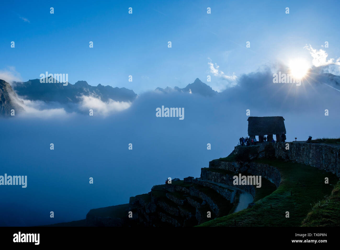 Tôt le matin, vue brumeuse de la maison de garde du Machu Picchu, Vallée sacrée des Incas. Touristes attendant la première lumière au lever du soleil, Machu Picchu Pérou. Banque D'Images