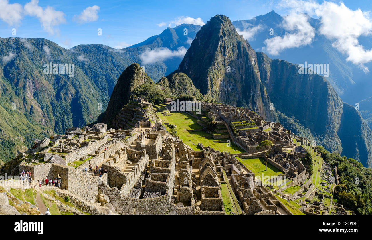 Tôt le matin, vue panoramique sur le Machu Picchu au Pérou, Huayna Picchu, la Vallée Sacrée des Incas. Les touristes visitant les ruines à la première lumière au lever du soleil. Banque D'Images