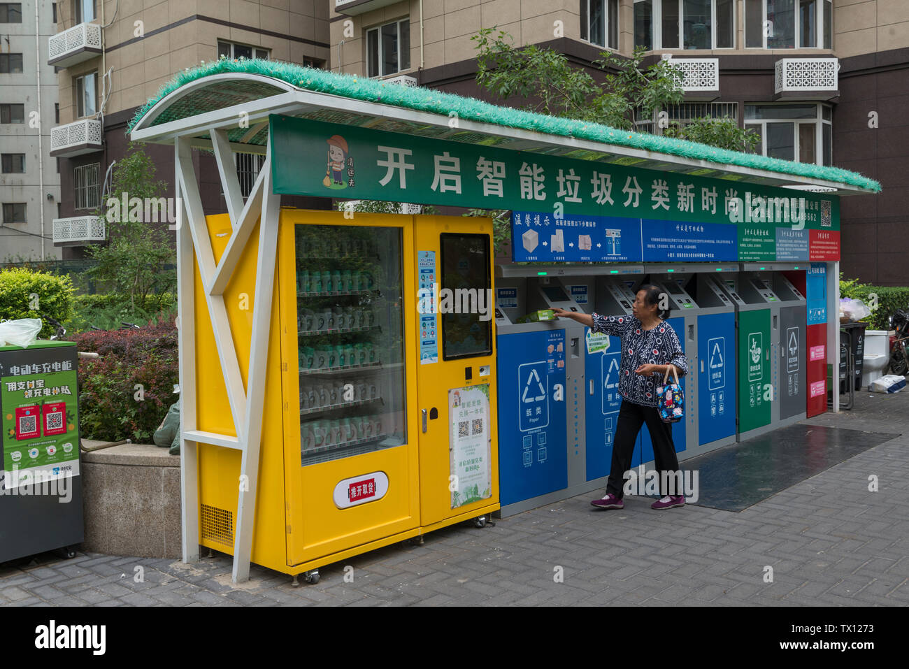 Une femme met les ordures dans l'une des poubelles de tri des déchets à puce dans un quartier résidentiel composé de Beijing, Chine. Jun 23, 2019 Banque D'Images