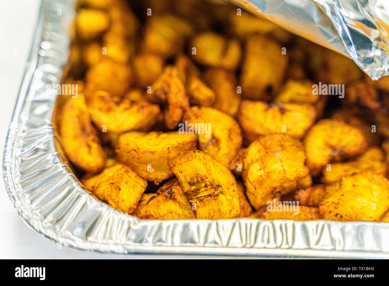 Plantain nigérian en dés dans récipient en aluminium servi au parti nigérian Banque D'Images