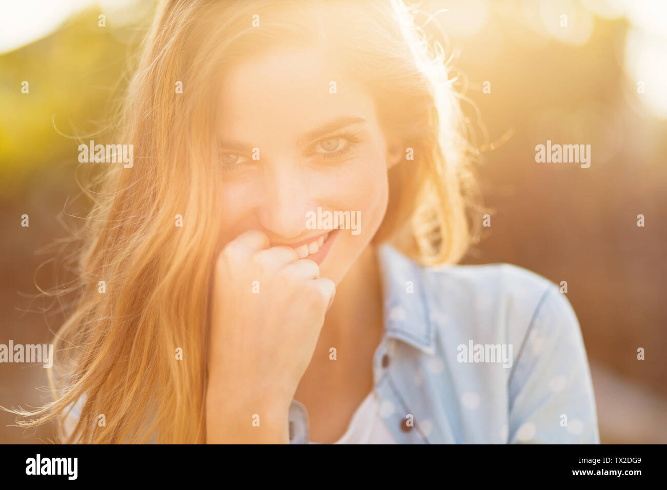 Magnifique Portrait fille avec un beau sourire et de beaux traits de visage sur une journée ensoleillée avec des rayons sur son visage. Douce, romantique, atmosphe Banque D'Images