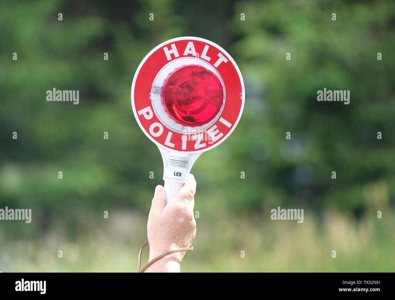 Klingenthal, Allemagne. 19 Juin, 2019. Au cours d'un contrôle de police, une femme policier est titulaire d'un voyant rouge d'une truelle dans l'air. Credit : Sebastian Willnow/dpa-Zentralbild/dpa/Alamy Live News Banque D'Images