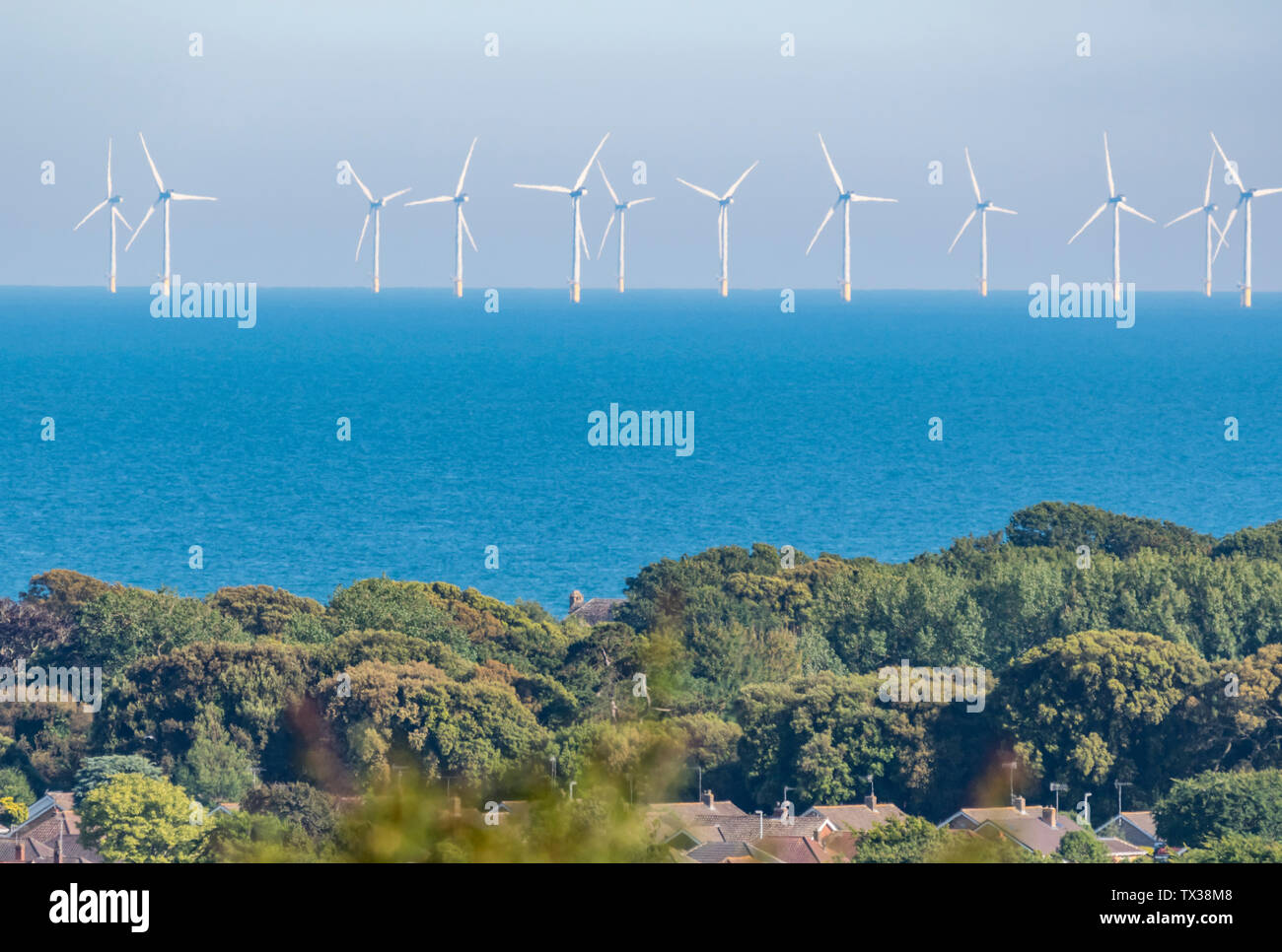 Rampion parcs offshore éoliennes dans la mer au large de la côte sud de l'Angleterre, Royaume-Uni, montrant la terre et du logement. L'énergie verte renouvelable. Le changement climatique. Banque D'Images