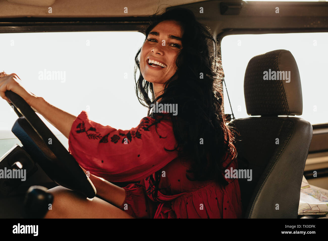 Cheerful young female conduisant une voiture. Belle femme voyageant en voiture sur la route. Banque D'Images