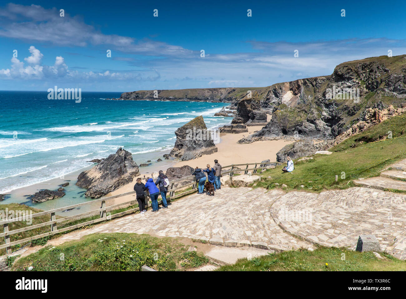 Les touristes debout sur la plate-forme panoramique profitant de la vue sur la nature, spectaculaire ; robuste Bedruthan Steps sur la côte nord des Cornouailles. Banque D'Images Les touristes debout sur la plate-forme panoramique profitant de la vue sur la nature, spectaculaire ; robuste Bedruthan Steps sur la côte nord des Cornouailles. Banque D'Images