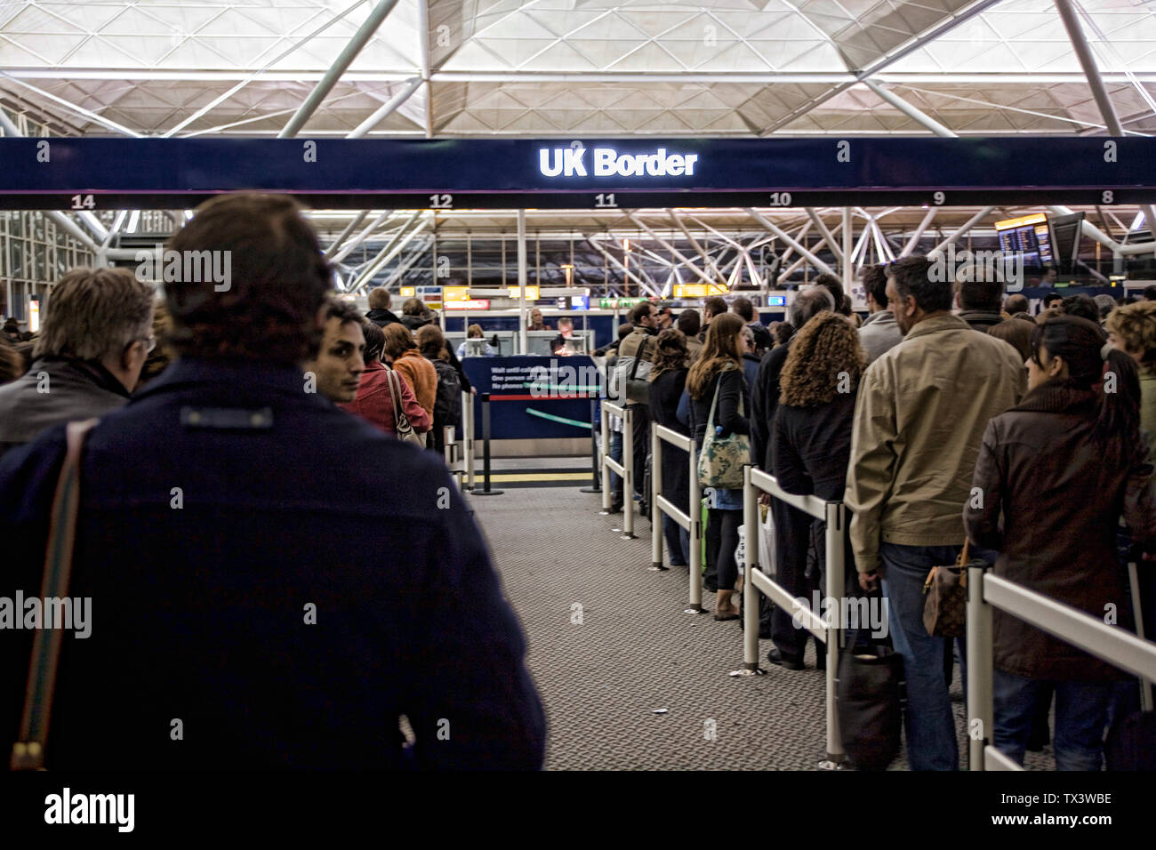 Personnes en attente à l'immigration aux frontières de l'aéroport de Stansted, Royaume-Uni, Londres, Angleterre, Europe. Banque D'Images