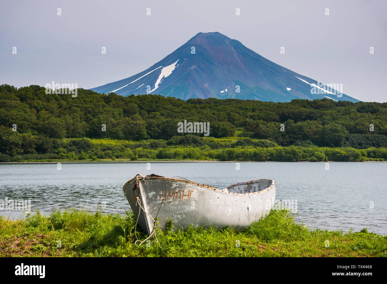 La Russie, Kamchatka, canot en bois avant le volcan et lac Kurile Ilyinsky Banque D'Images