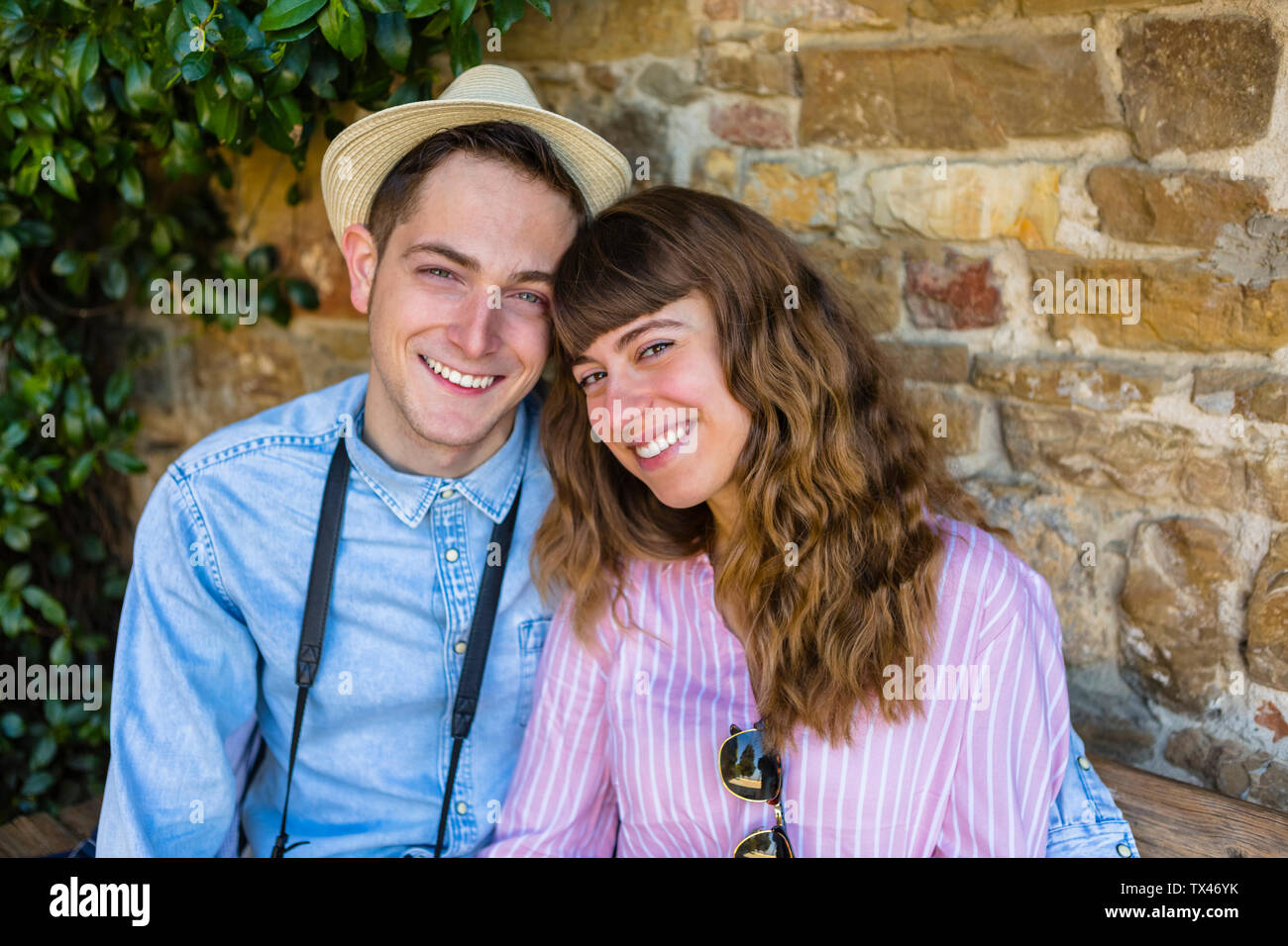Jeune couple sur un séjour en ville, assis sur un banc, prenant une pause Banque D'Images
