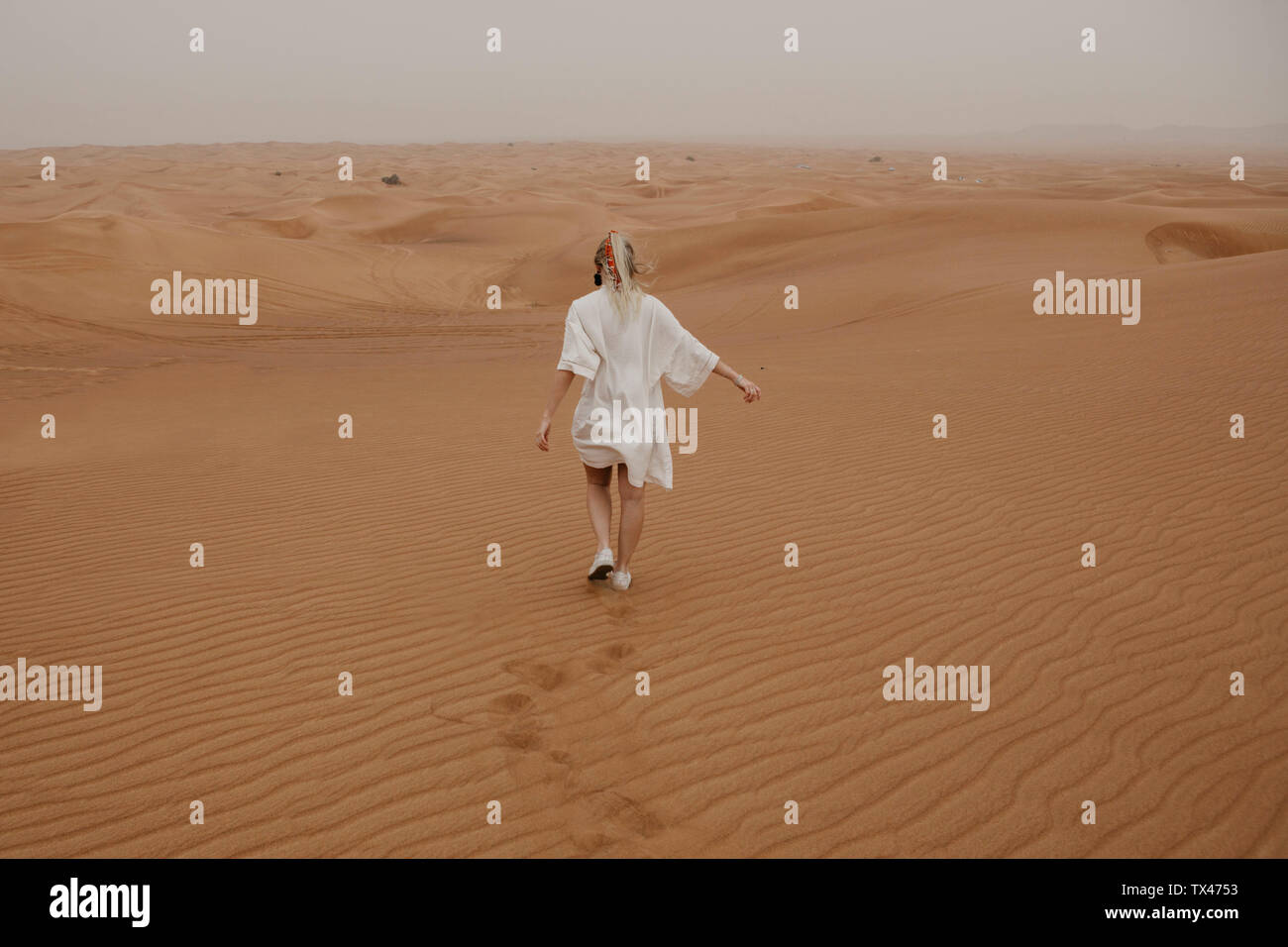 Emirats arabes unis, dubaï, Lahbab Désert, woman walking in desert landscape Banque D'Images