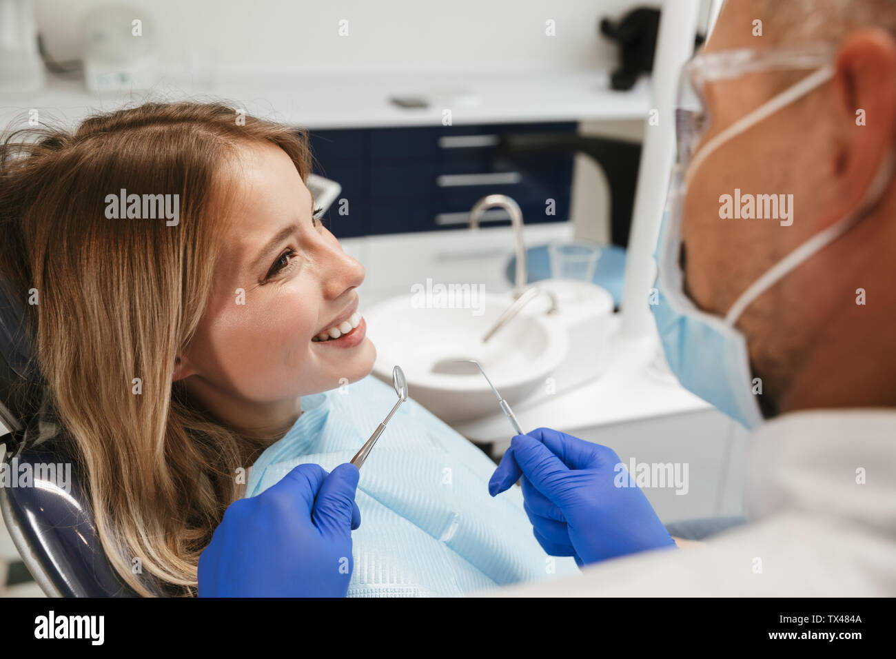 Image de caucasian woman fauteuil dentaire au centre médical médecin professionnel tout en fixant ses dents Banque D'Images