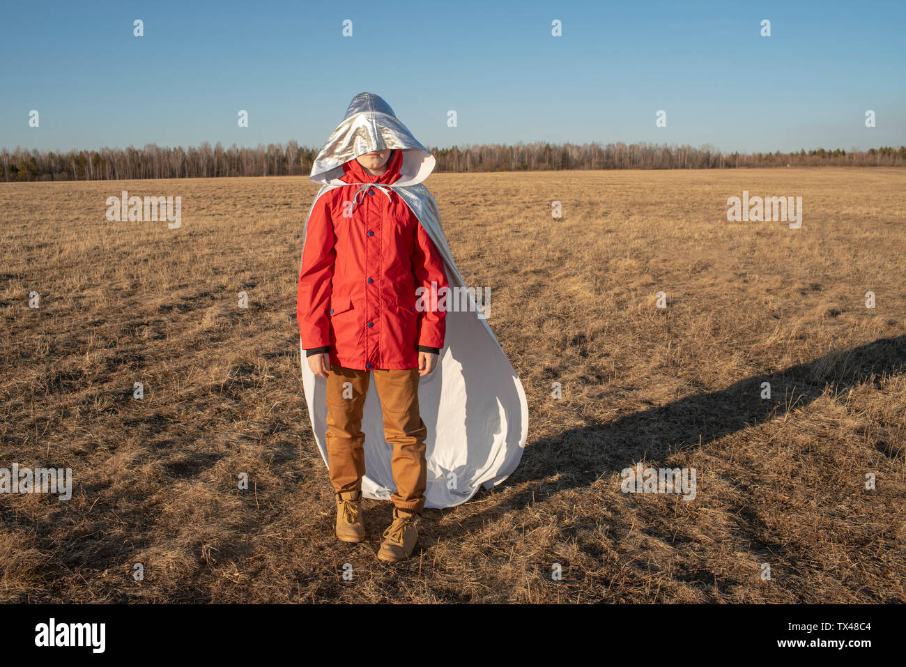 Capot de superhero costume couvrant visage du garçon dans un paysage de steppe Banque D'Images