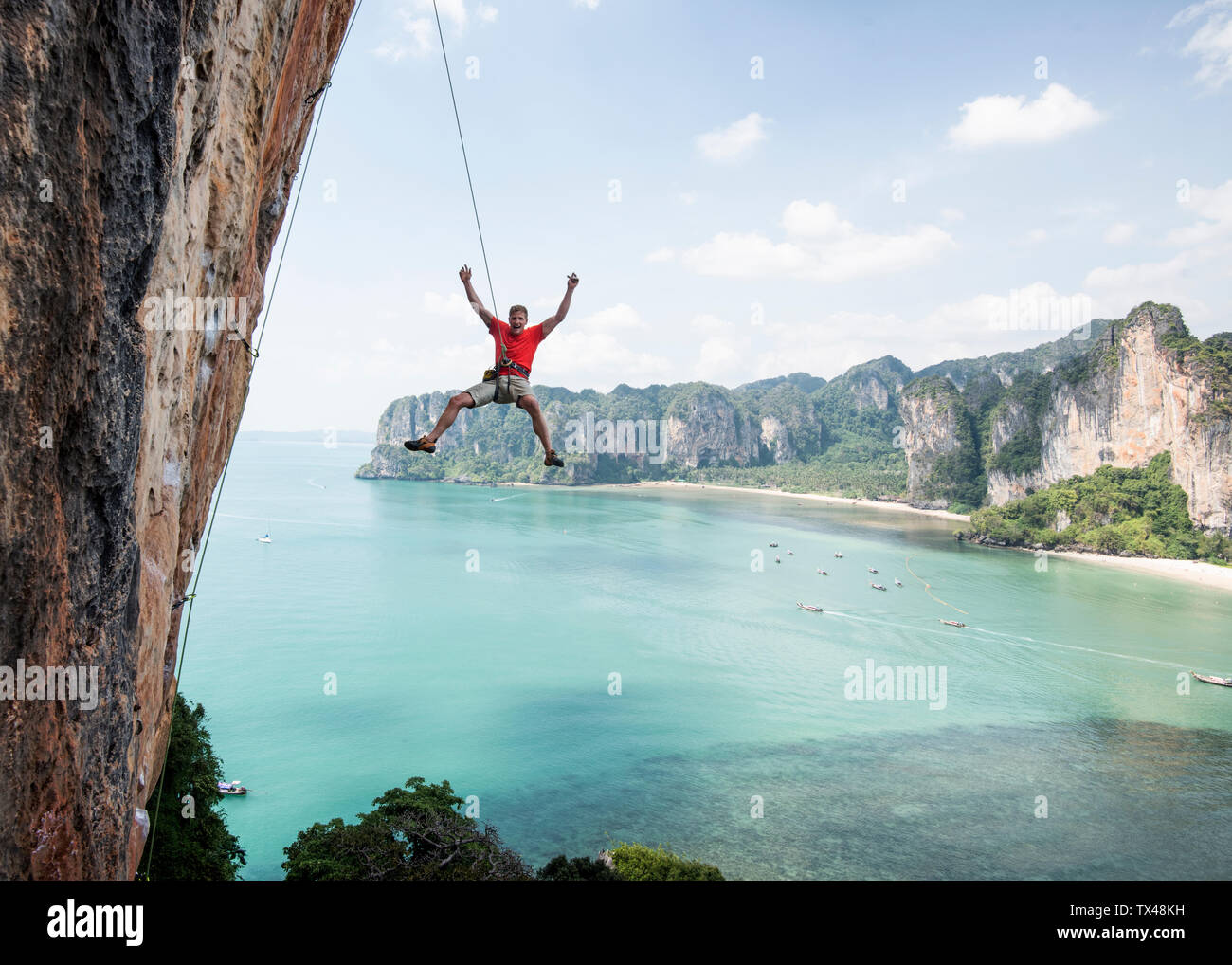 La Thaïlande, Krabi, Thaiwand wall climber abseiling, à partir de la paroi de rochers au-dessus de la mer Banque D'Images