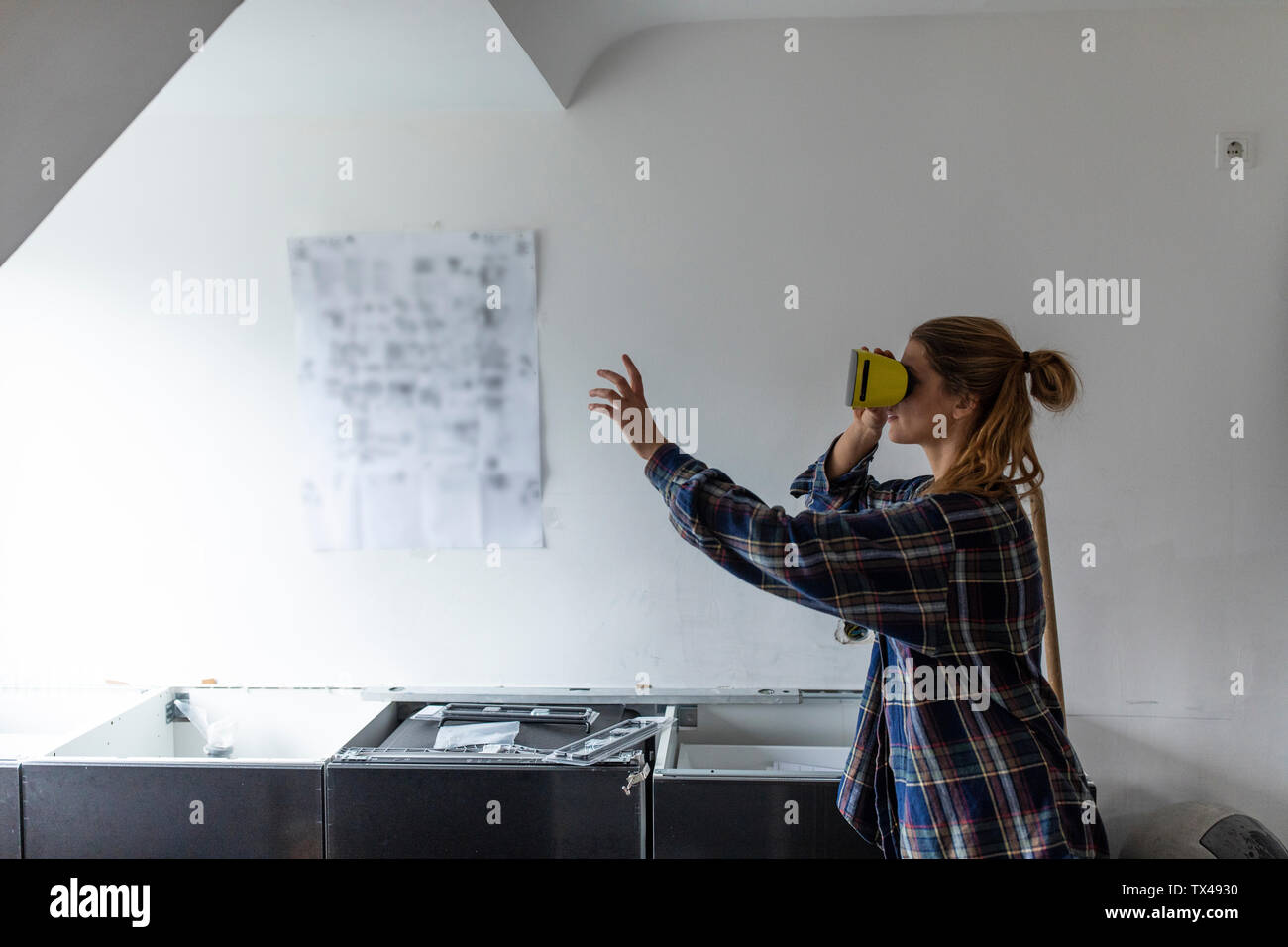 Jeune femme portant des lunettes VR avec des instructions de montage au mur cuisine Banque D'Images