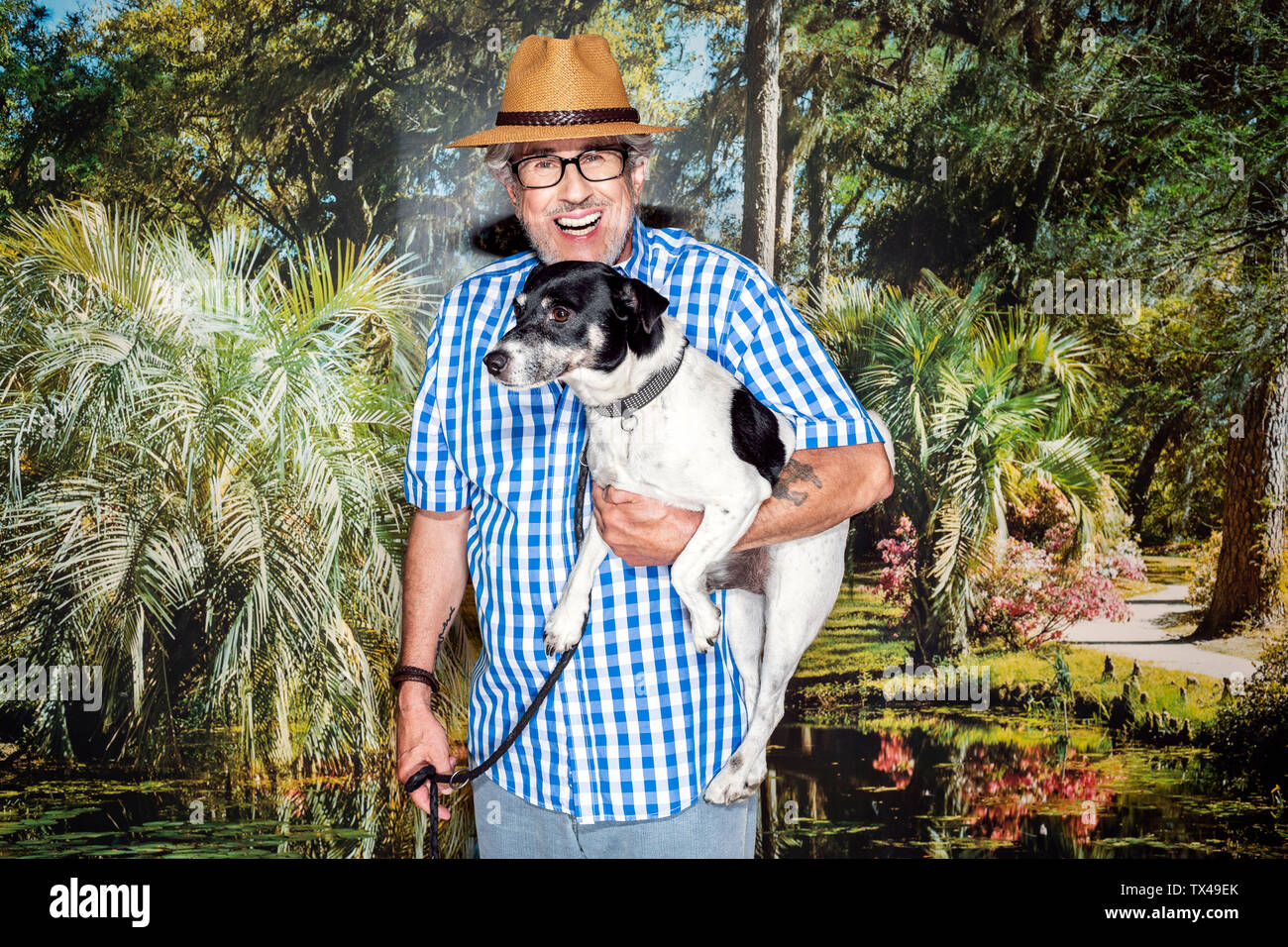 Man avec un chapeau et un chien, debout en face de papier peint photo Banque D'Images
