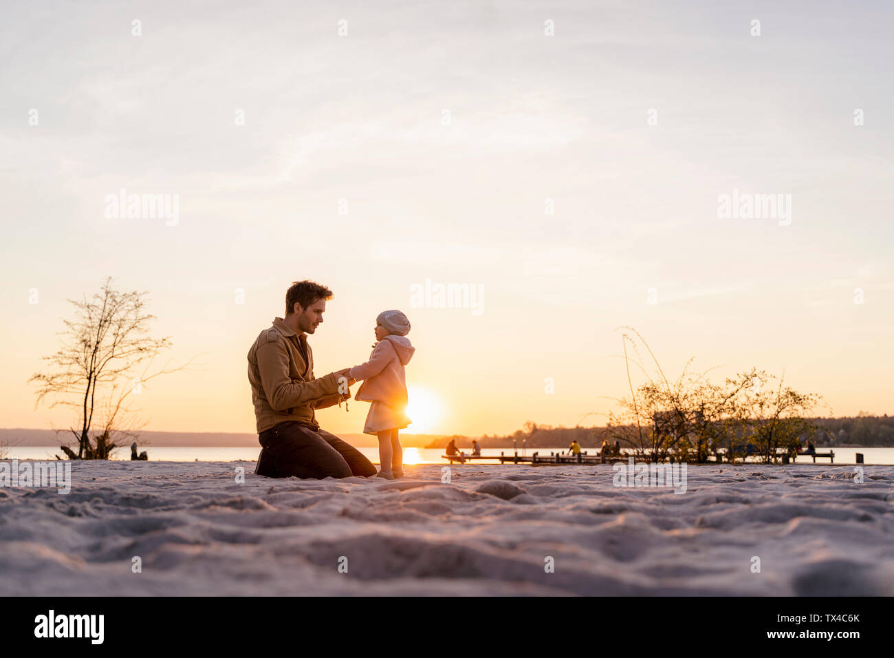 Allemagne, Bavière, Ostfildern, père et fille jouant sur la plage au coucher du soleil Banque D'Images