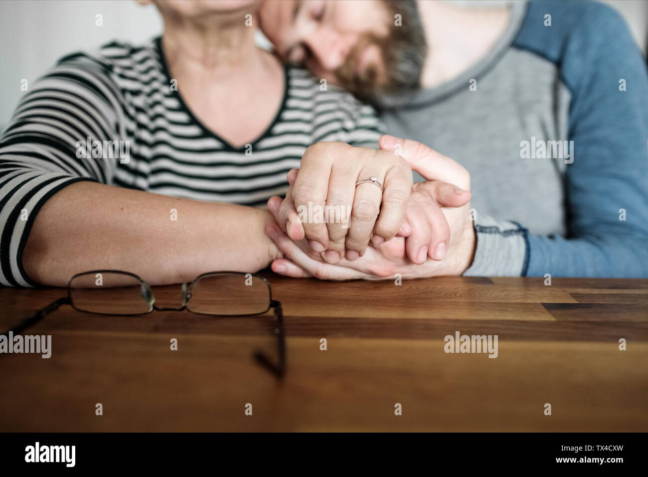 Close-up de son fils adulte affectueux et senior mother holding hands at home Banque D'Images