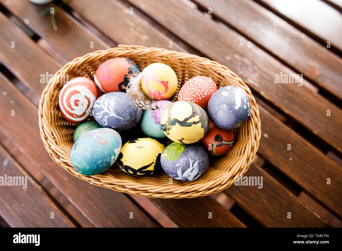 Oeufs de Pâques dans un panier sur la table en bois Banque D'Images