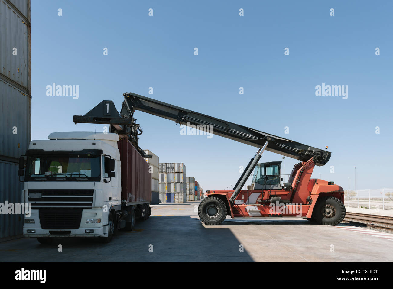Le levage à la grue sur camion conteneur sur site industriel Banque D'Images