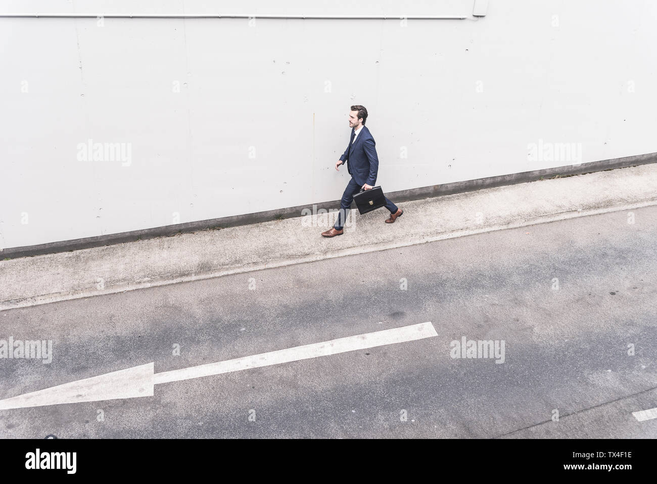 Businessman walking à route avec panneau de flèche Banque D'Images