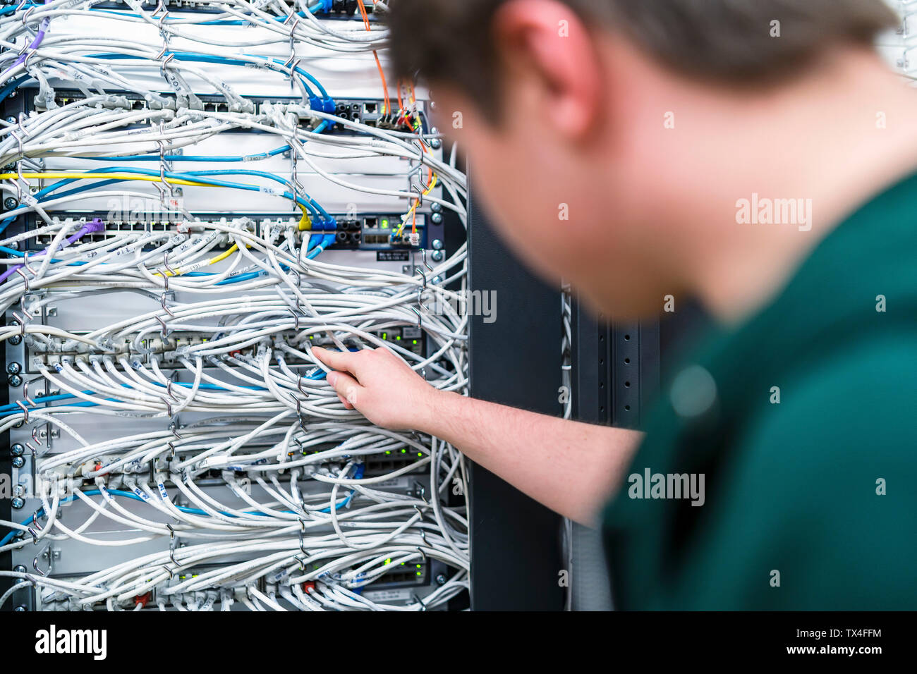Close-up of adolescent travaillant avec les câbles dans la salle serveur Banque D'Images