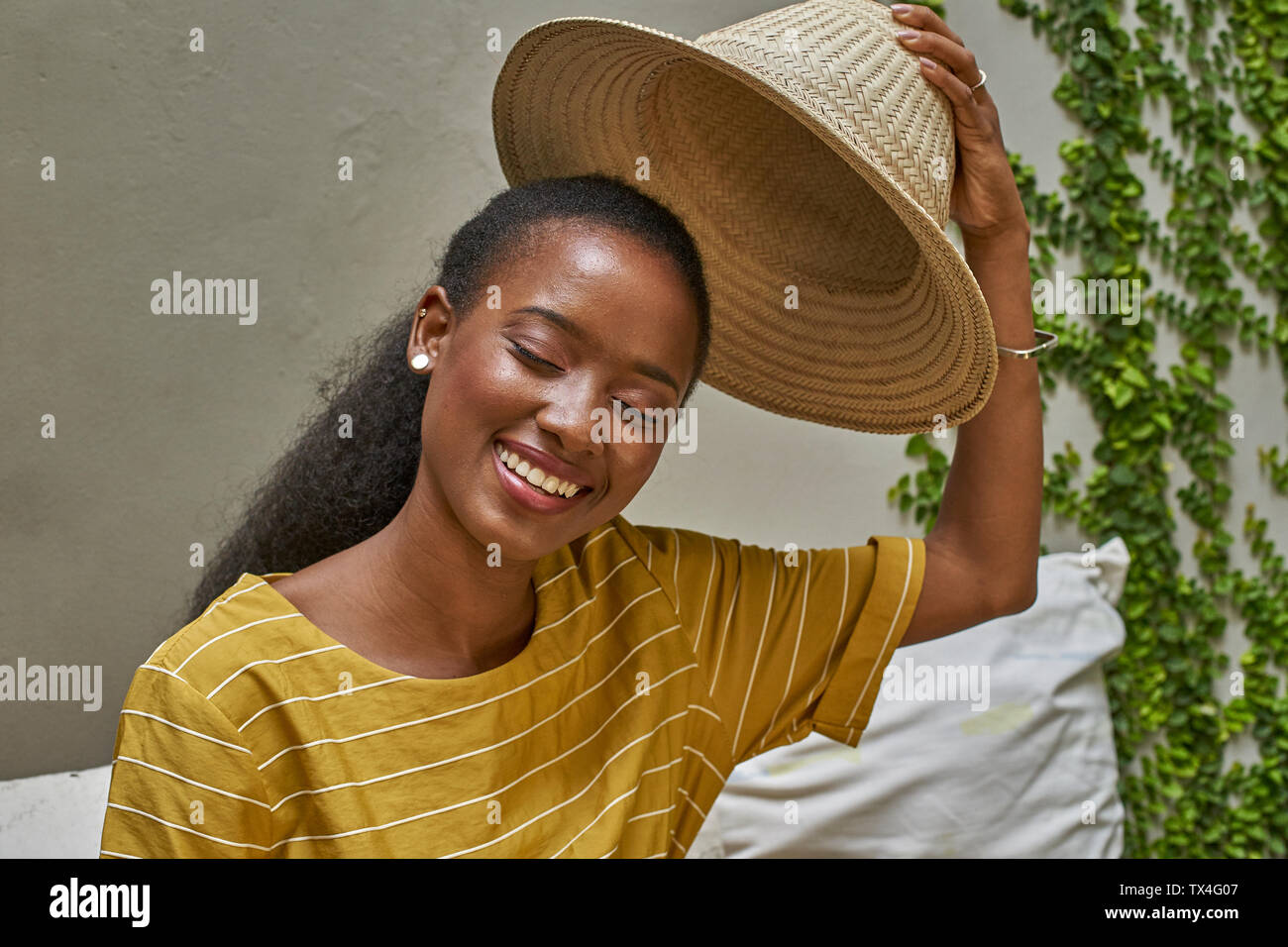 Portrait of happy woman putting sur un chapeau traditionnel Banque D'Images