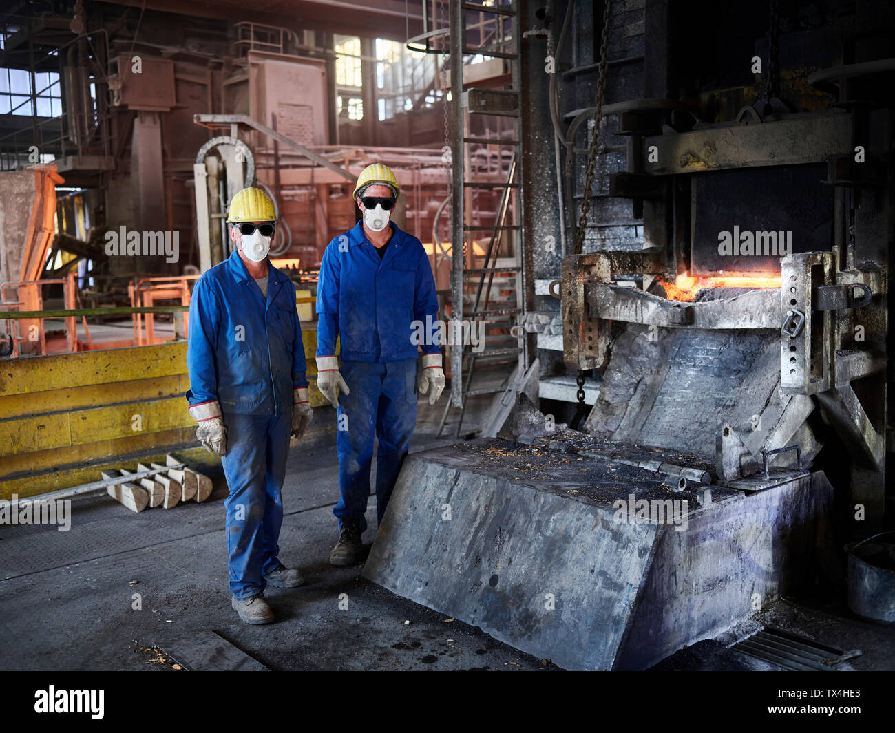 L'industrie, Smelledery : Les travailleurs en face de haut fourneau avec casque et masque anti-poussière Banque D'Images
