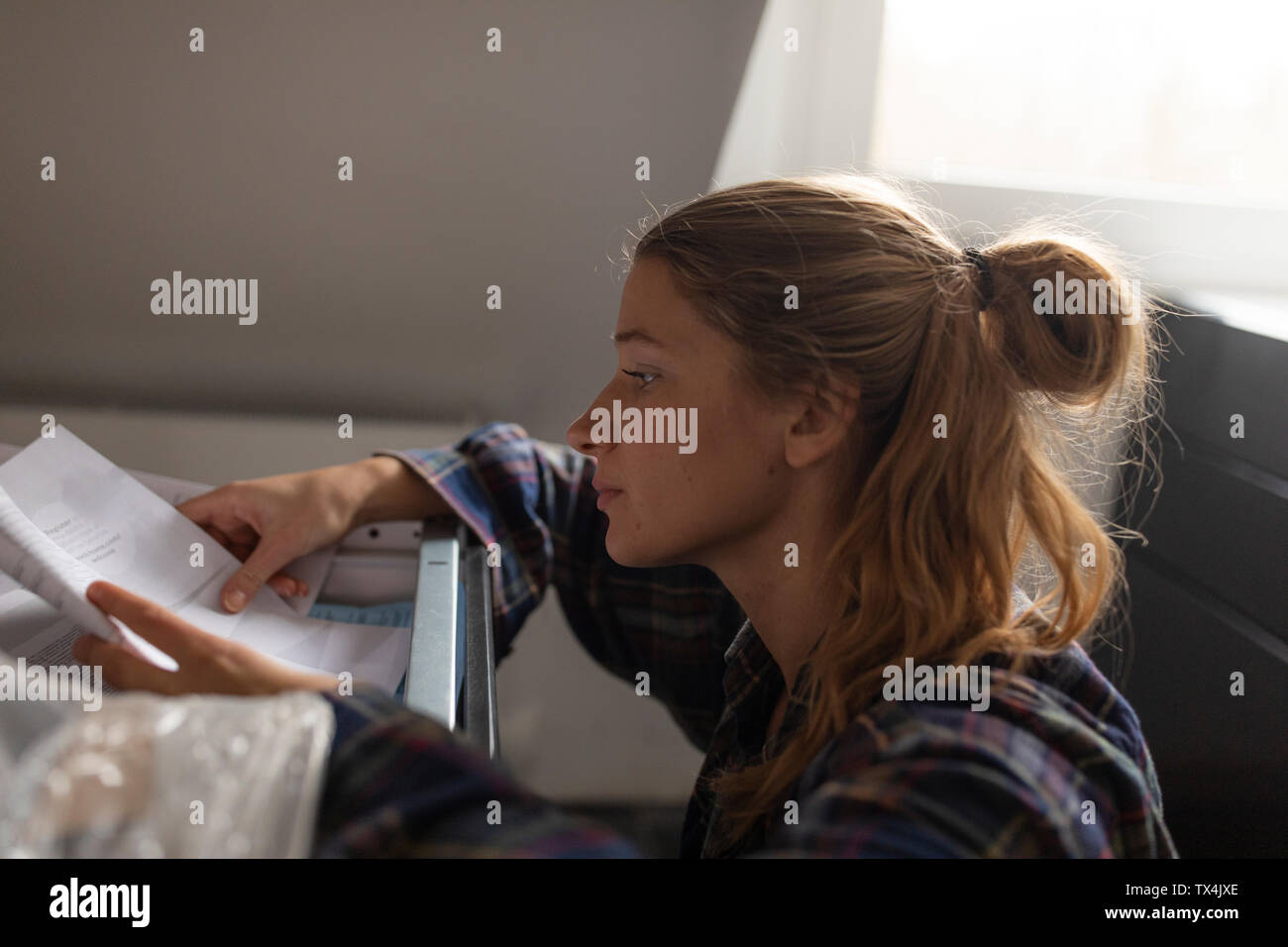Jeune femme étudie les instructions de montage dans la cuisine Banque D'Images