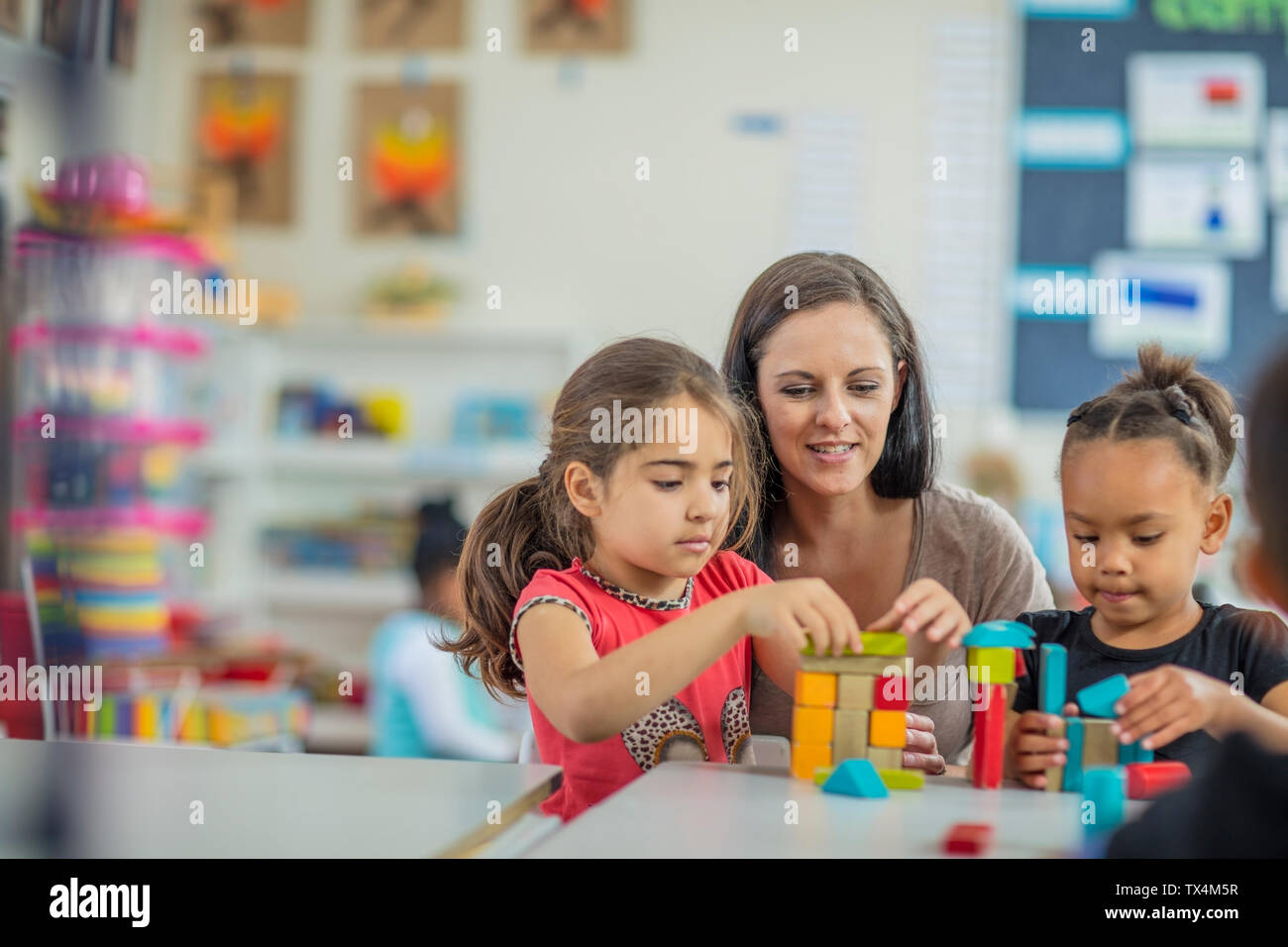Enseignante préscolaire jouer avec les filles de la maternelle Banque D'Images