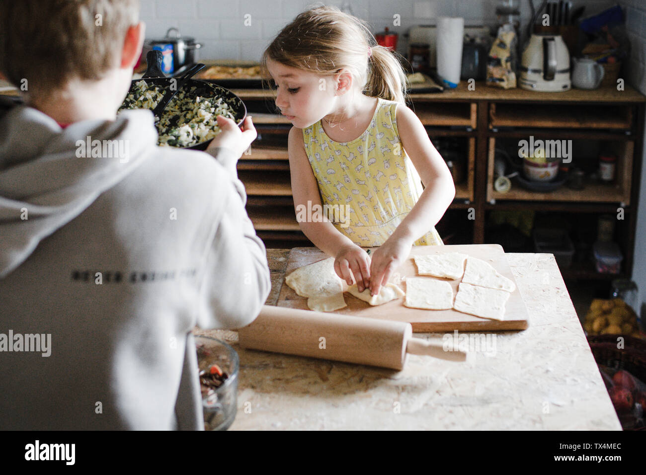 Petite fille et son frère aîné la préparation de pâtisserie farcie dans la cuisine Banque D'Images