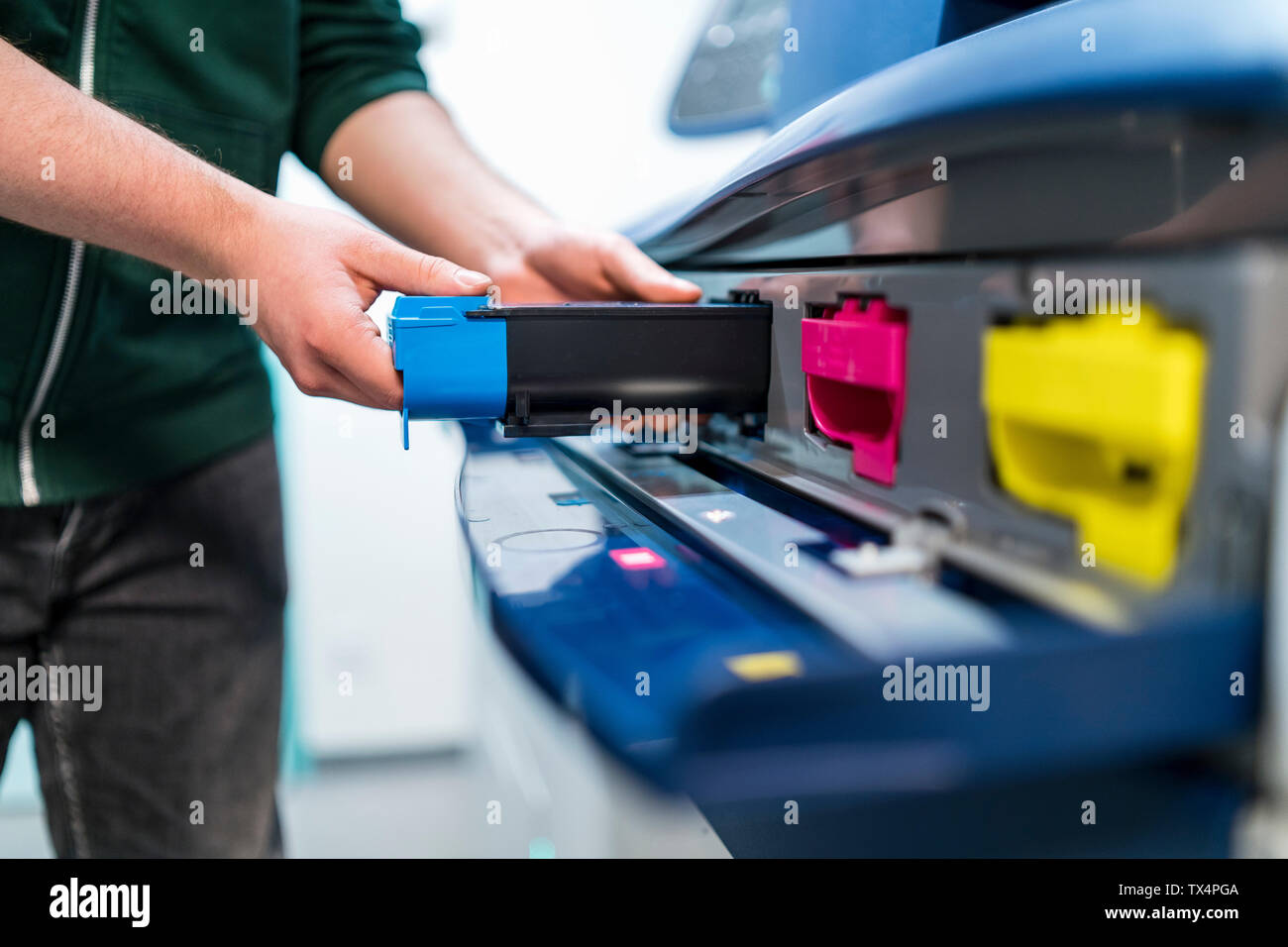 Close-up of adolescent travaillant à l'insertion de cartouche d'imprimante couleur Banque D'Images