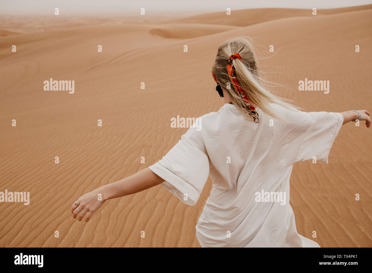 Emirats arabes unis, dubaï, Lahbab Désert, woman walking in desert landscape Banque D'Images