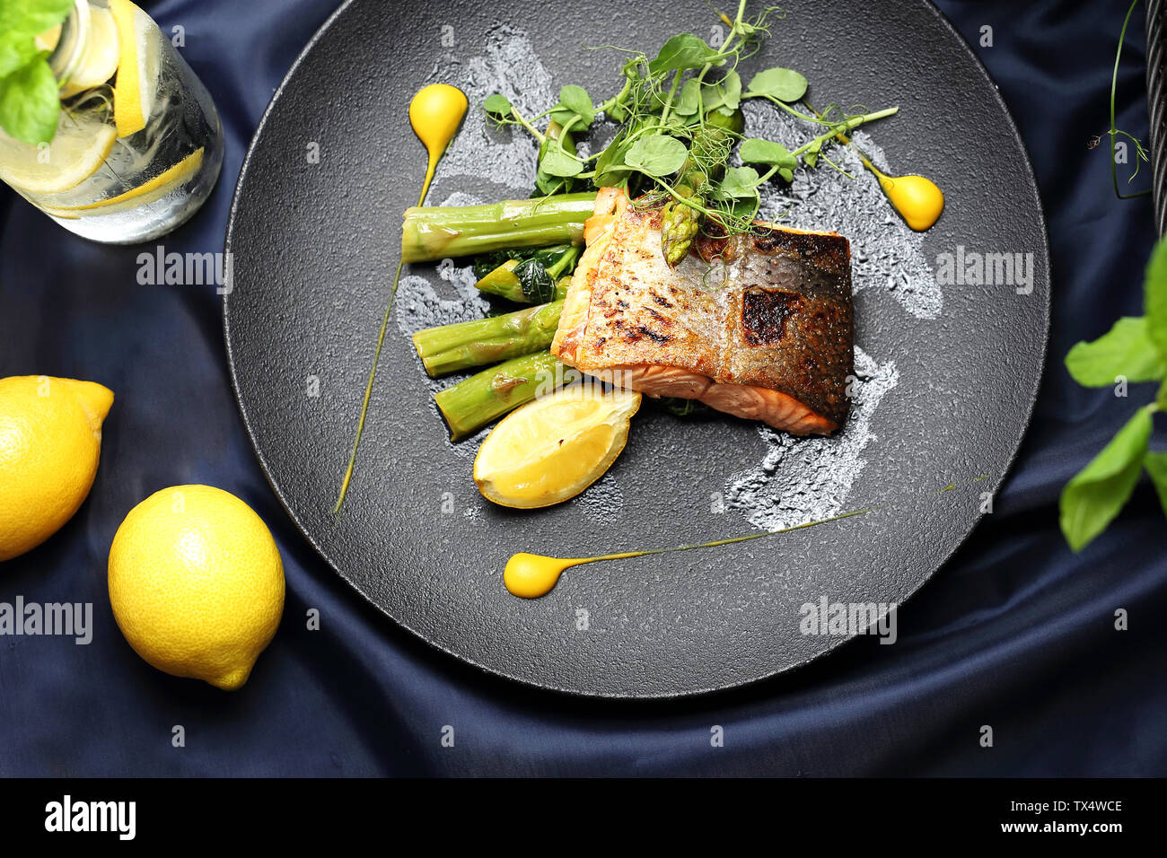 Filet de saumon cuit au four avec sauce au citron servi sur les asperges vertes. Un élégant plat exquis. Banque D'Images